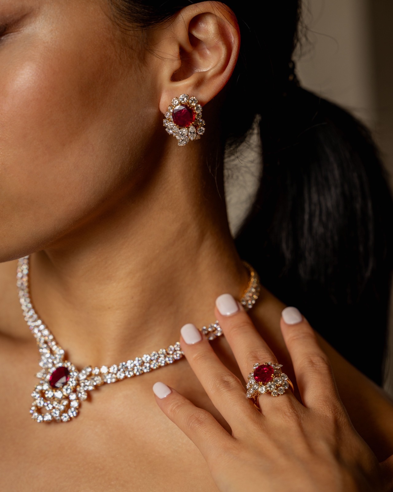 A ruby and diamond necklace, earrings and ring worn together