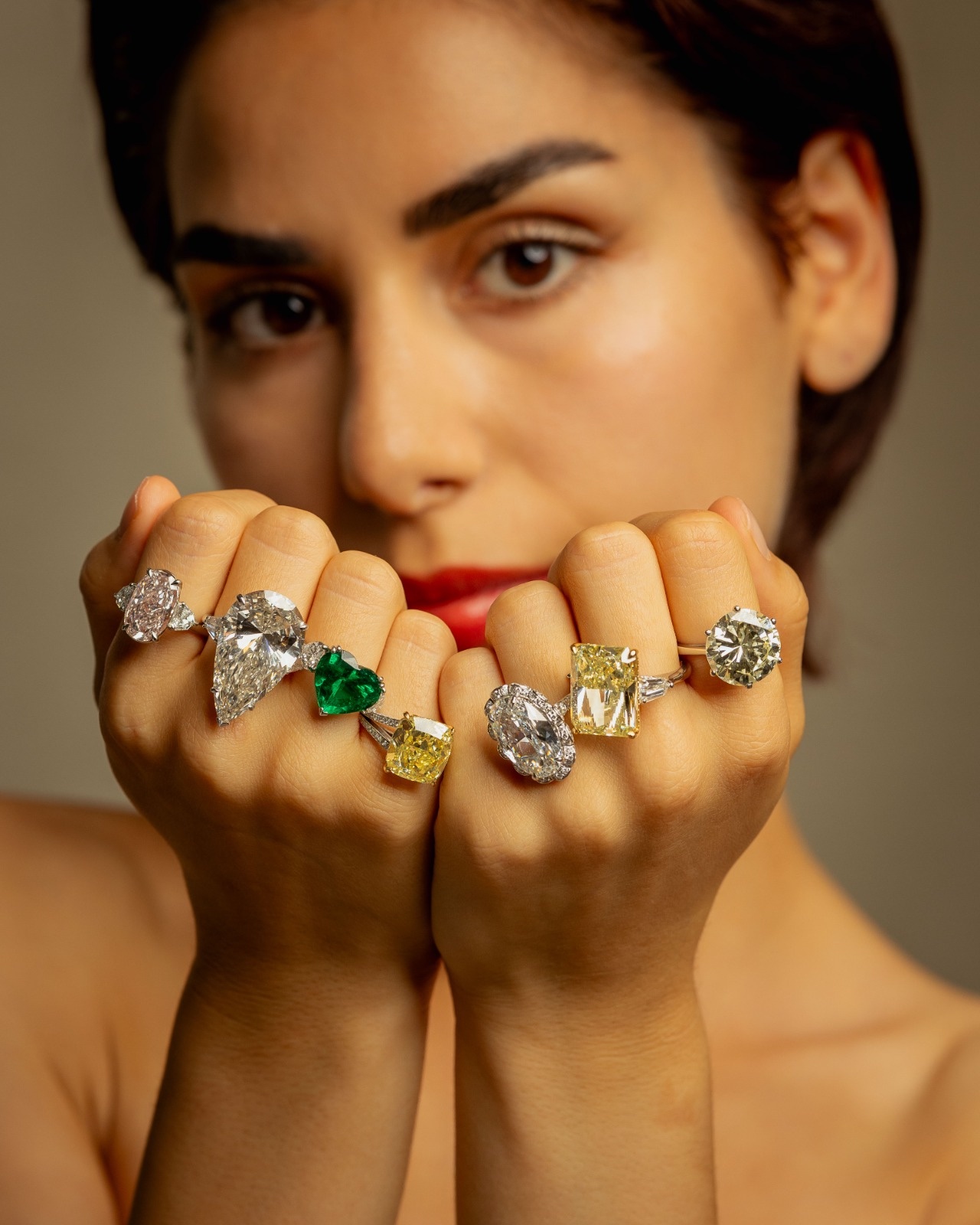 Seven diamond and gemstone rings worn across both hands