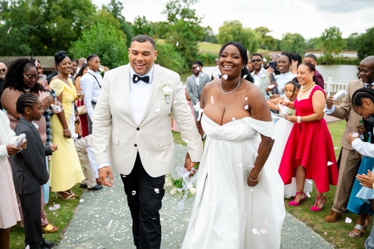A newly married couple walking through confetti